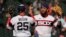 El tercera base cubano Yoán Moncada junto al primera base Andrew Vaughn celebran la victoria de los Medias Blancas sobre los Atléticos de Oakland, en Chicago, este domingo, 27 de agosto de 2023. (AP Foto/Nam Y. Huh)