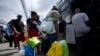 Migrantes de Venezuela abordan un autobús al Aeropuerto Internacional de Tocumen en Ciudad de Panamá, el miércoles 26 de octubre de 2022. (AP Foto/Arnulfo Franco).