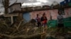 Residentes del barrio de Regla caminan sobre los escombros en busca de sus pertenencias.