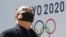 Un hombre se protege del coronavirus frente a un logo de los Juegos de Tokio. AP Photo/Koji Sasahara