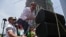 Juan Guaidó, presidente interino de Venezuela, sube a una tarima improvisada para hablarle al público en Caracas el 1ro de mayo de 2019. (AFP).